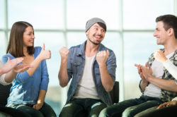 man celebrates with the people in his addiction recovery support group