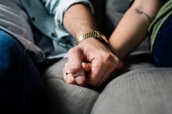 closeup of two hands of two people holding each other as an act of support