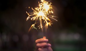 closeup of a hand holding holiday fireworks sparklers