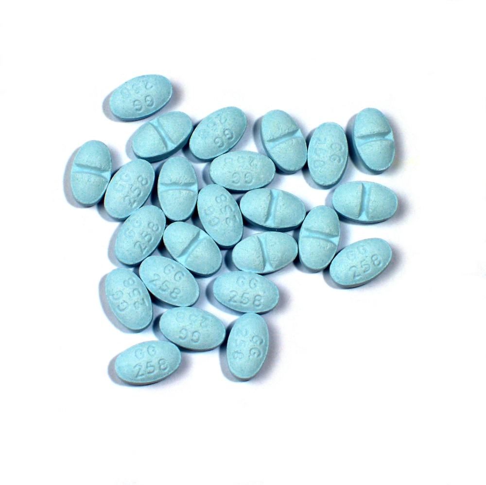 Blue Xanax tablets on a white background