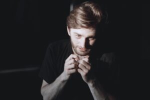 An addicted man holding a small plastic bag of drugs