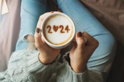 A woman holding a cup of coffee with number 2024