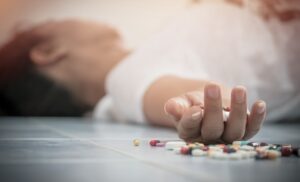 Unconscious male lying on the floor with scattered antidepressants