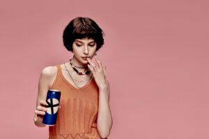 Woman looking at a can of alcoholic drink