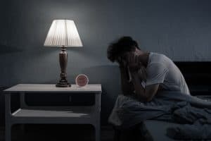 Man sitting on the bed not being able to sleep