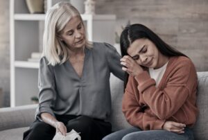 Female crying while speaking to an addiction specialist