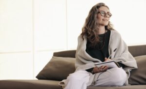 Elderly woman in the couch journaling about her sobriety 