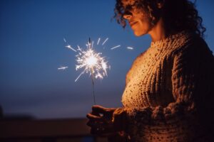 Woman with closed eyes holding a sparkler setting a New Year intention
