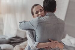 Couple hugging each other after male partner admits to needing addiction treatment