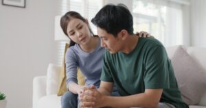 Woman comforting her husband who is struggling with addiction 