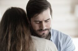 Man in blue shirt hugs his wife for loving an addict like himself