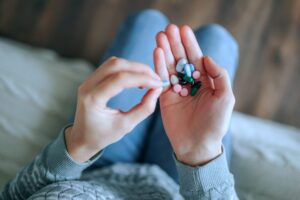 Woman holding out different muscle relaxer drugs on her palm