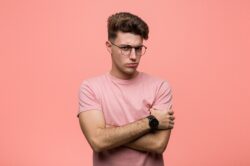 Young man in pink wondering how to stay sober when his friends are not sober from alcohol drinking
