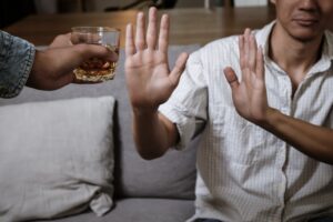 Man declining an offer of a drink from a friend