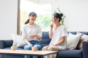 Two women in addiction recovery talking in a sober home