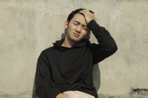 Young man on the floor greening out from too much weed use