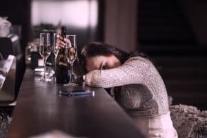 Drunk woman in a bar after drinking glasses of champagne